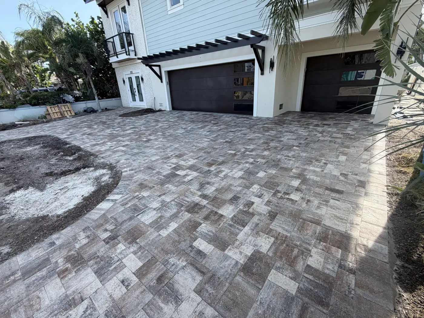 Finished gray paver driveway at a two-story coastal home
