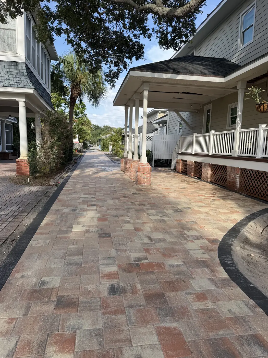 Red and tan paver driveway with a charcoal soldier-course border