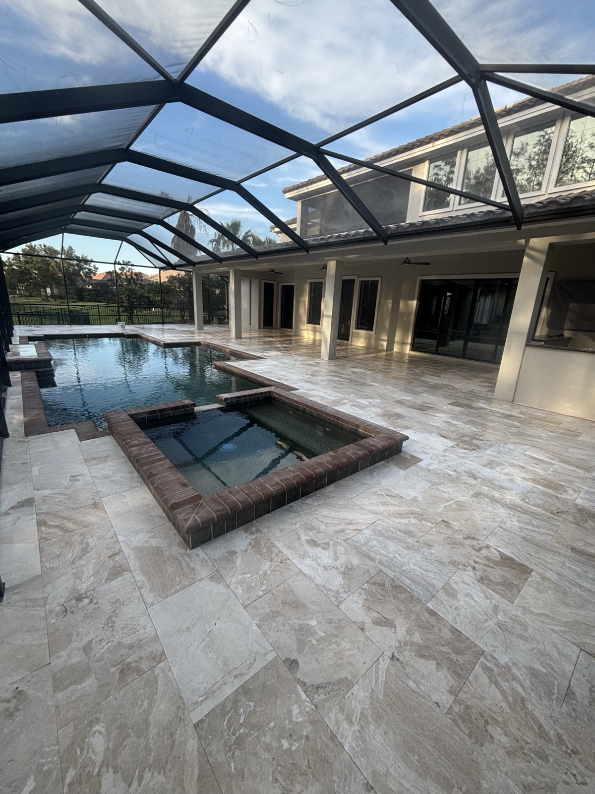 French-pattern travertine pool deck installed by BayWave Home & Outdoors in Tampa Bay
